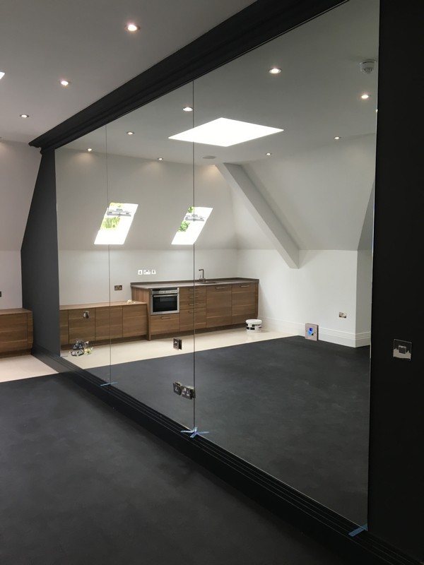 Frameless glass partition in loft conversion by Wallington glaziers